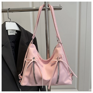 Detail of pink shoulder bag with double bow ribbons and vertical silver zippers decoration