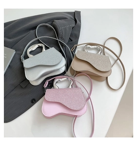 Détail de sacs bandoulière multicolores avec patchwork pailleté et poignées en cœur