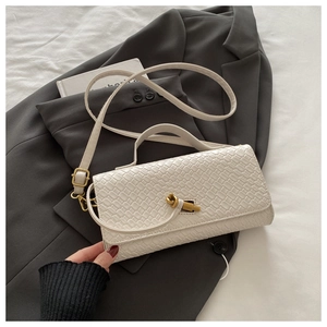 Detail of white woven texture shoulder bag with elegant gold knotted metal twist lock