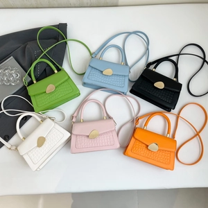 Sacs à bandoulière colorés motif crocodile avec boucles dorées sur un fond blanc épuré