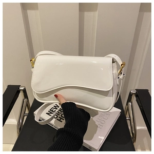 Détail du sac à bandoulière en cuir verni blanc avec rabat vague et anneau doré