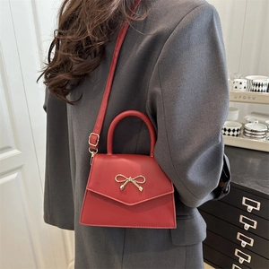 Minimalist red envelope crossbody bag with a gold bow accent for women