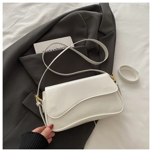 Détail du sac à bandoulière en cuir verni blanc avec rabat irrégulier et boucle dorée