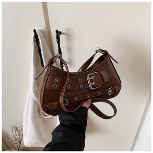 Detail of vintage coffee brown shoulder bag with metal buckles and rivet decorations