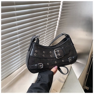 Detailed view of punk-style black crescent bag featuring silver buckles and metal eyelets