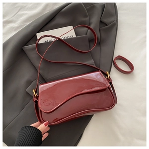 Détail du sac à bandoulière en cuir verni rouge vin avec rabat ondulé et fini brillant