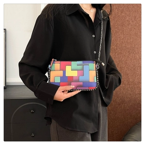 Détail d'un sac bandoulière géométrique coloré avec chaîne à billes et bandoulière métal