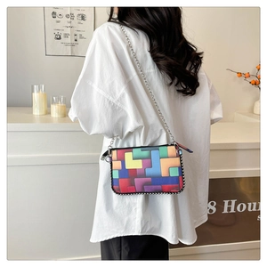Détail du motif géométrique coloré et de la chaîne argentée sur le petit sac carré