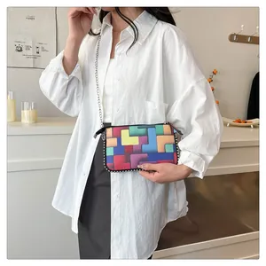 Détail du sac bandoulière à motif Tetris coloré avec chaîne argentée sur modèle