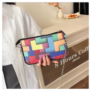 Détail du sac à main patchwork géométrique coloré avec chaîne argentée et fermeture éclair