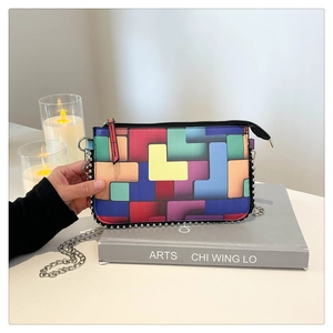 Détail du motif géométrique coloré sur le sac avec garniture de perles argentées et chaîne