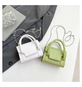Detail of mini crocodile pattern bags in white and green with silver chain straps