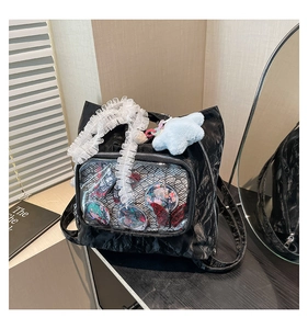 Detail of black pleated ita-bag with clear window showing anime pins and lace straps