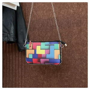 Vue détaillée du motif géométrique coloré avec bordure de perles argentées sur le sac