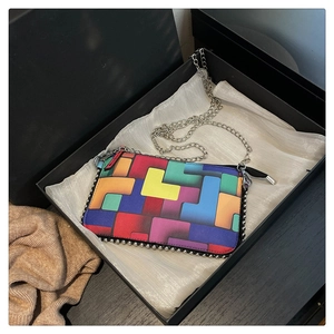 Vue détaillée du sac à main géométrique coloré dans un coffret cadeau noir élégant