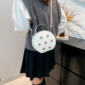 Chic white circular crossbody bag with trendy silver ball studs and detachable chain strap