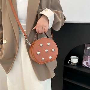 Brown round crossbody bag with silver rivet studs and adjustable strap for women