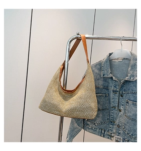Close-up of beige woven texture and brown leather strap on a large hobo tote bag