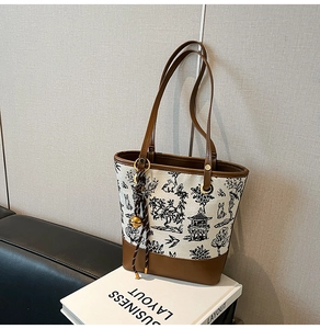 Detail of Chinese print canvas tote bag featuring rabbit motifs and leather trim details