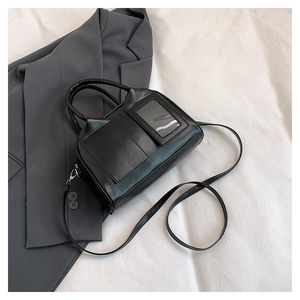 Detail view of black Boston bag with dual front utility pockets and silver hardware