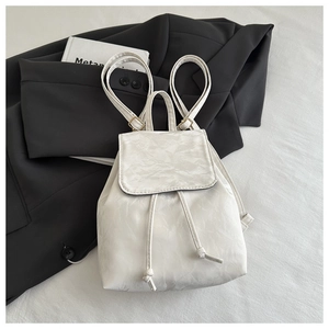 Détail du sac à dos blanc à texture plissée et cordon de serrage sur veste noire
