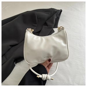 Detail of white leather shoulder bag with gold hardware and FASHION & BAGS text