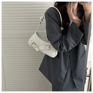 Chic white shoulder bag with gold metal eyelets and knotted strap detail shown on model