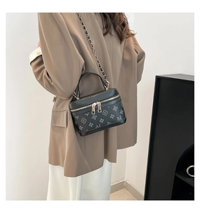 Detail view of stylish crossbody box bag with vintage monogram patterns and chain strap