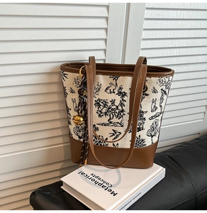 Detailed view of canvas tote bag featuring traditional ink landscape print and leather trim