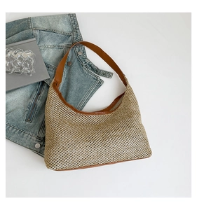 Detailed weave of beige straw tote bag with brown PU leather trim on white background