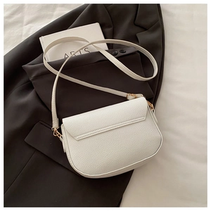 Close-up of white lychee pattern leather crossbody bag with elegant gold metal buckle detail