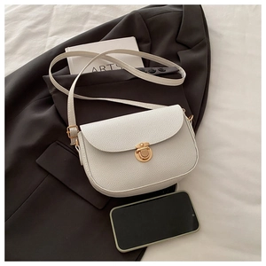Detail of white lychee-pattern saddle bag with gold metal buckle and adjustable strap