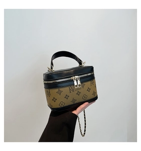 Detailed macro view of monogram pattern and gold metal hardware on luxury box bag