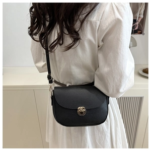 Detail of classic black lychee grain leather crossbody bag with golden rotating metal lock