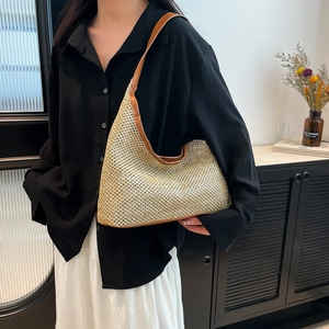 Vintage woven tote bag with brown leather trim shown on model for casual vacation style