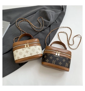 Overhead view of luxury mini box bags with monogram patterns and metal chain straps