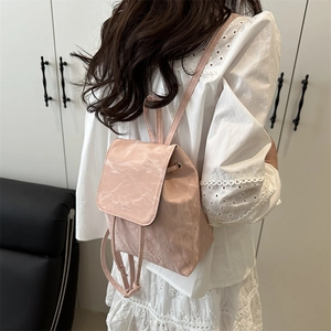 Sac à dos rose texturé avec cordon de serrage et fines bretelles porté par un mannequin