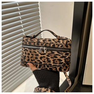 Detail of leopard print box bag with dual metal zippers and matching shoulder strap