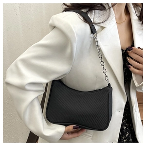 Detail of matte black shoulder bag with silver chain strap and diagonal woven texture