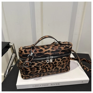 Detail view of leopard print crossbody bag featuring double zippers and a textured surface