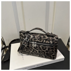 Detail view of leopard print box bag with silver zipper on a white prop book