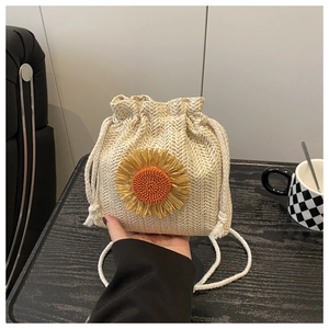 Detail of hand-woven bucket bag with large sunflower ornament and drawstring closure