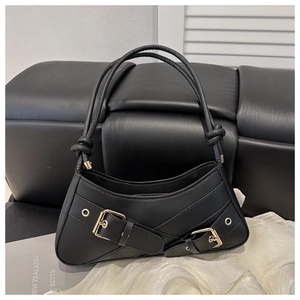 Detail view of black underarm bag featuring dual metal buckles and twisted rope handle