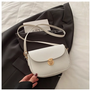 Close-up of white lychee leather saddle bag featuring a premium gold metal clasp