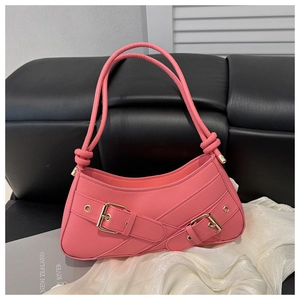 Detailed view of the pink leather underarm bag with golden buckles and knotted strap