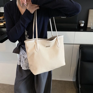 Chic beige woven tote bag for women with gold hardware in a modern lifestyle setting