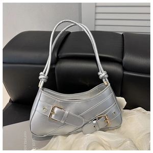 Detail of silver Y2K shoulder bag with dual buckle straps and metallic finish
