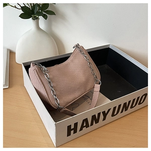 Detail of pink herringbone fabric shoulder bag with silver chain and textile strap