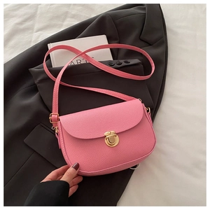 Detail shot of a pink crossbody bag featuring textured lychee grain and a gold clasp