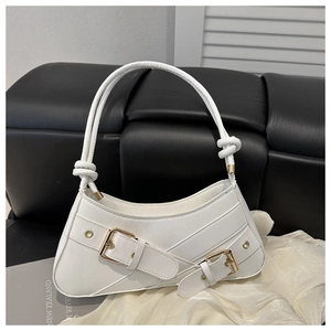 Detail of white leather underarm bag featuring dual metal buckles and knotted strap handle
